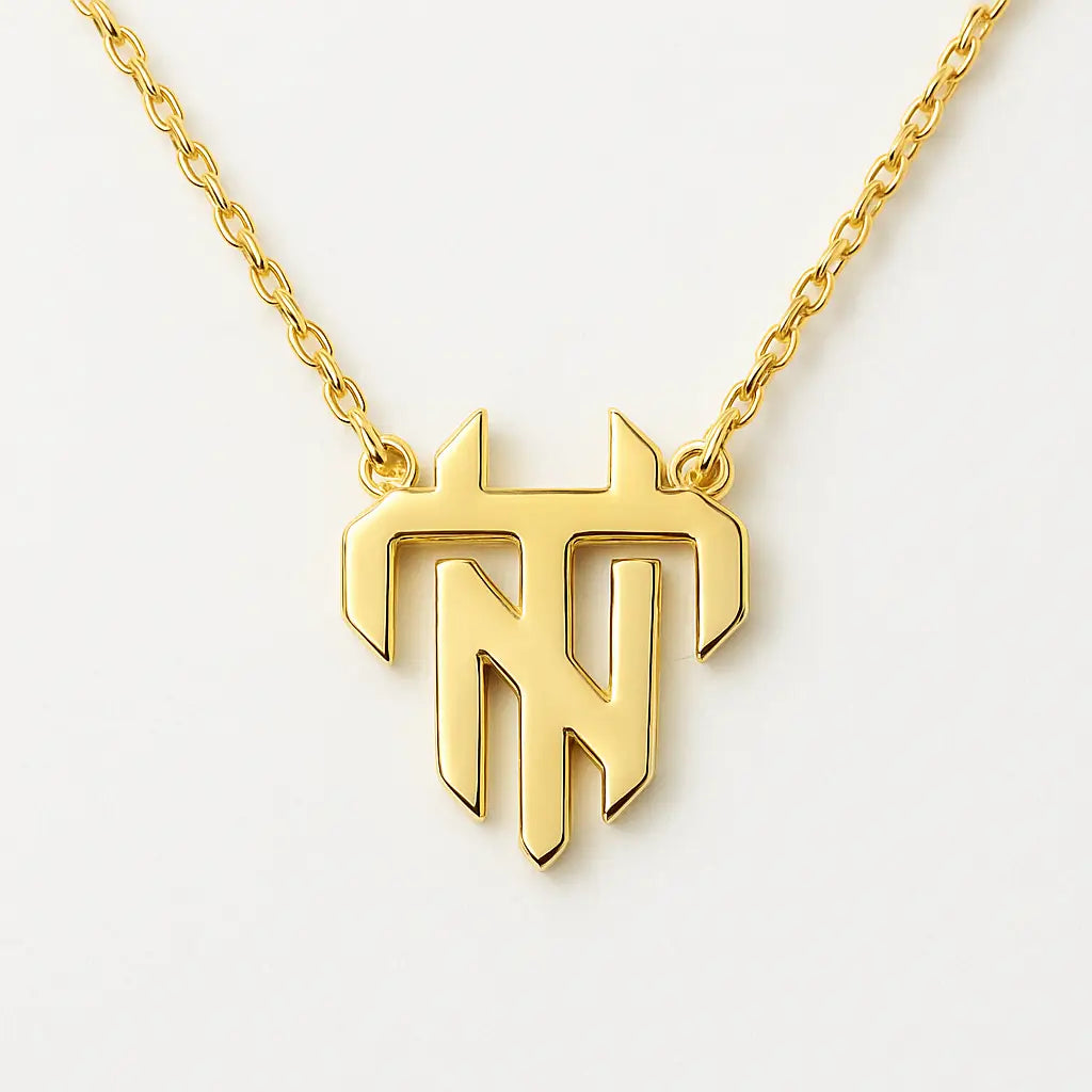 Gold necklace with a unique pendant on a light gray background